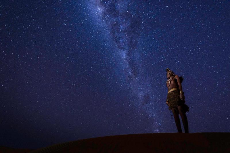 Eine Person starrt in den tiefblauen Sternenhimmel