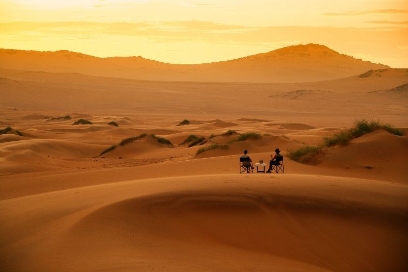 Couple enjoying sundowners in the desert of Namibia