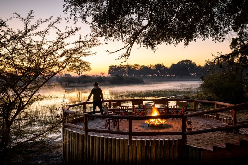 Mann an einer Feuerstelle im Chief's Camp - eine der nachhaltigen Unterkünfte in Botswana