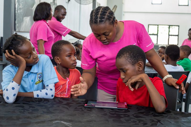 A facilitator at the Good Work Foundation’s Hazyview campus assisting young learners with a tablet-based activity.
