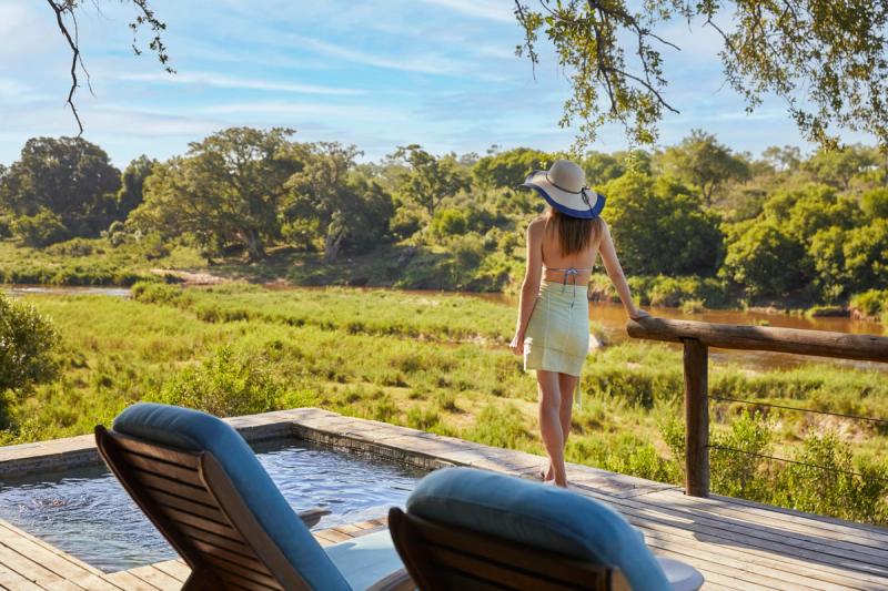 Huésped junto a una piscina privada con vistas al río y a la vegetación circundante.