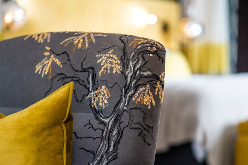 Close up photograph showing the detailed embroidered knobthorn tree on the corner of a couch