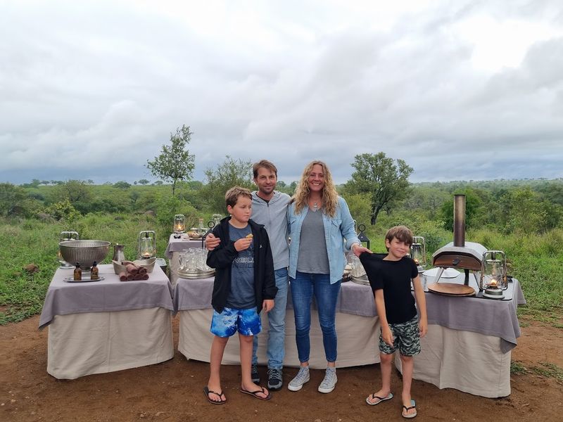 A family stands in front of a buffet while on safari in the Kruger