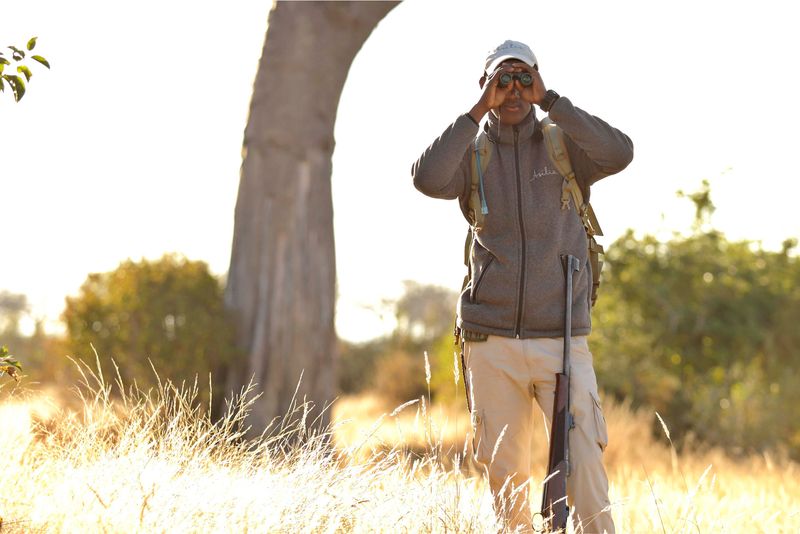 One of Asilia Africa's guides looking through a pair of binoculars