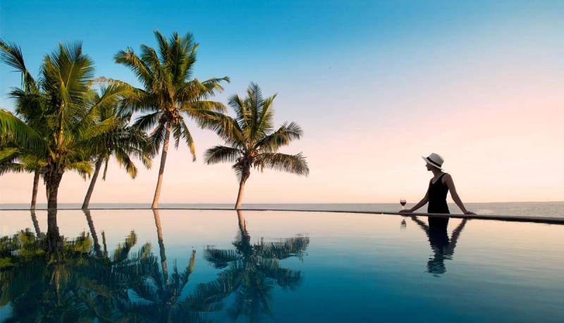 Swimming pool with palm trees, surrounded by scenic views