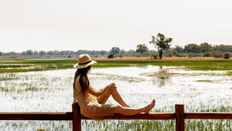 Woman sitting and looking out at Okavango Delta view in Botswana