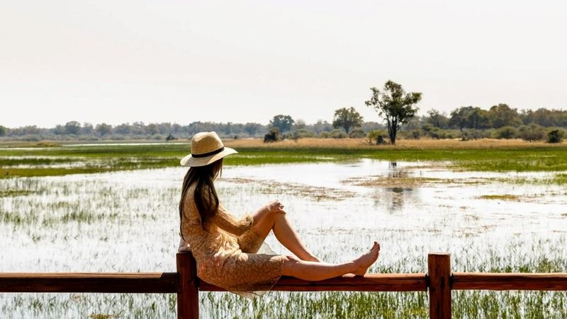 Woman sitting and looking out at Okavango Delta view in Botswana