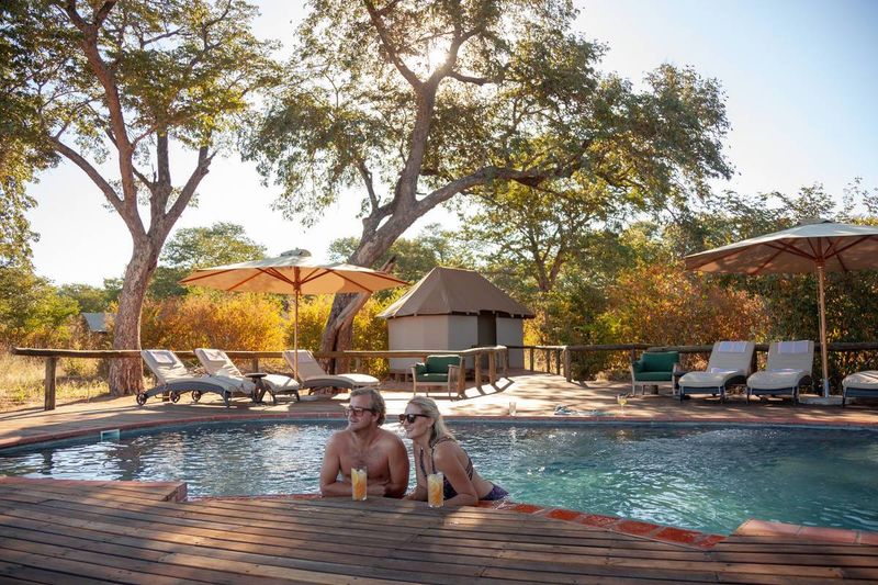 Auf Safari in Simbabwe: Paar erfrischt sich im Swimmingpool im Verney's Camp