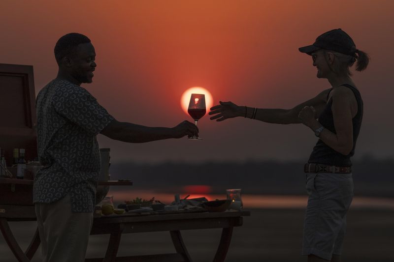 Sundowner drinks by the Zambezi River during a Lower Zambezi safari in Zambia