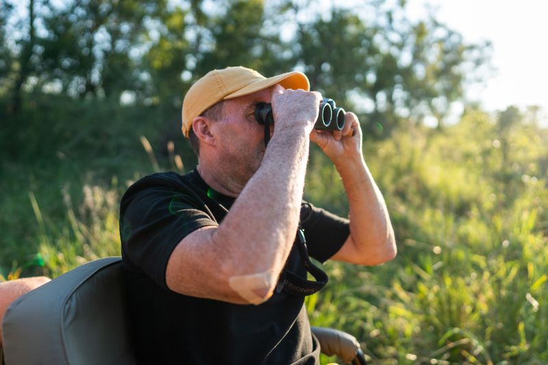Rhino Africas CEO David Ryan blickt durch ein Fernglas - auf der Suche nach den Reisetrends für 2025