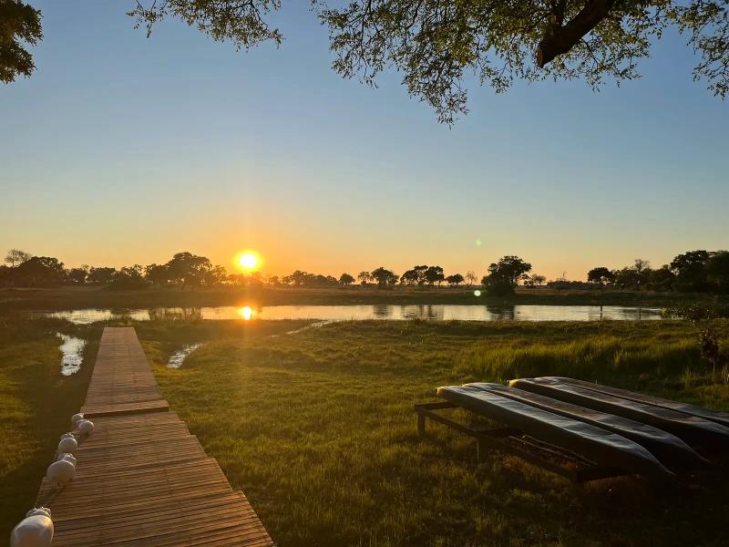 Pôr do sol sobre uma lagoa em um acampamento de safári da &Beyond no Delta do Okavango, em Botsuana.