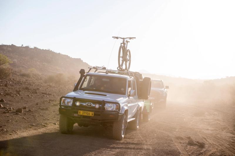Transport vehicle with bike atop driving through the desert