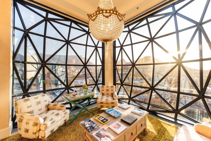 A sunlit lounge with grand windows framing Table Mountain, inside one of the luxury hotels in Cape Town