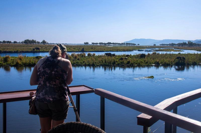 Woman looking out at the Zambezi from wooden deck in Zambia