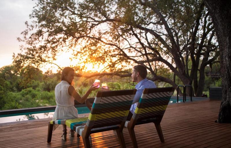 Couple drinking gin and tonic at Silvan Safari pool during sunset