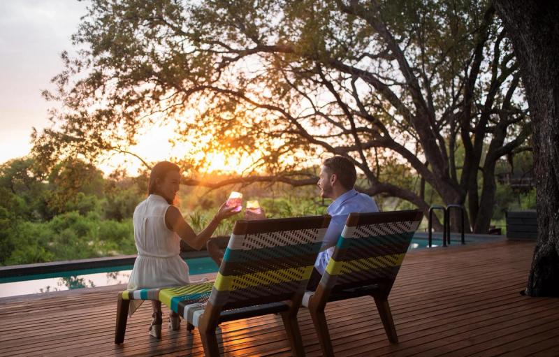 Couple drinking gin and tonic at Silvan Safari pool during sunset