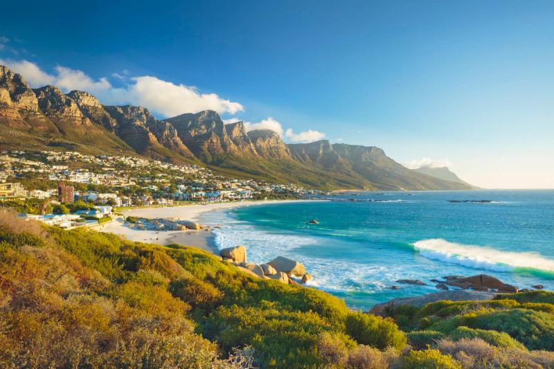A sunlit coastal view of Cape Town’s Camps Bay contradicts the tone of recent travel advisory reports