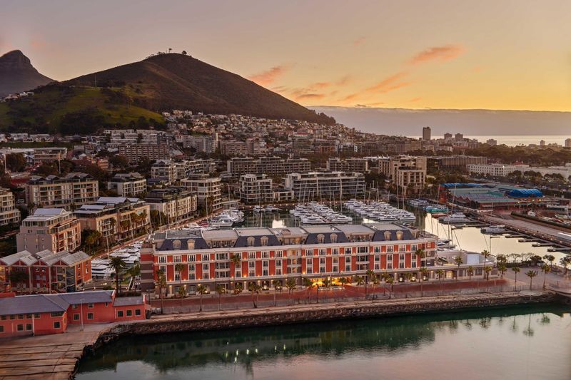 An aerial view of Cape Grace, one of the luxury hotels in Cape Town, framed by a marina and the city’s rising hills