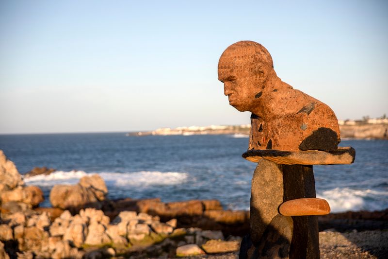 A rust-toned coastal sculpture overlooks the sea in Hermanus