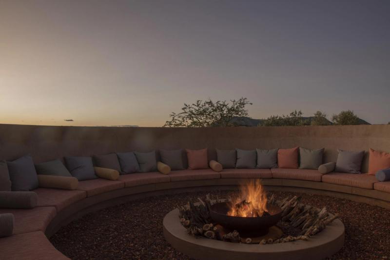 A round boma with cushioned seats and a firepit