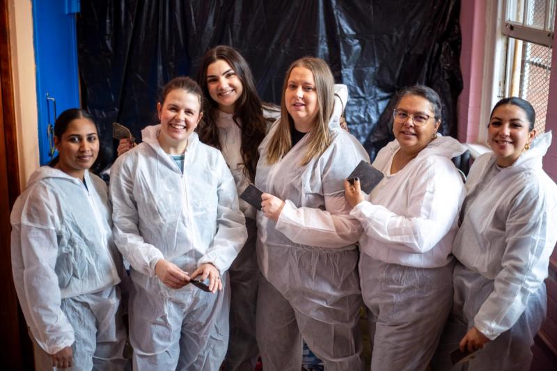 A group of Rhino Africa volunteers smile together during a classroom painting project on Mandela Day