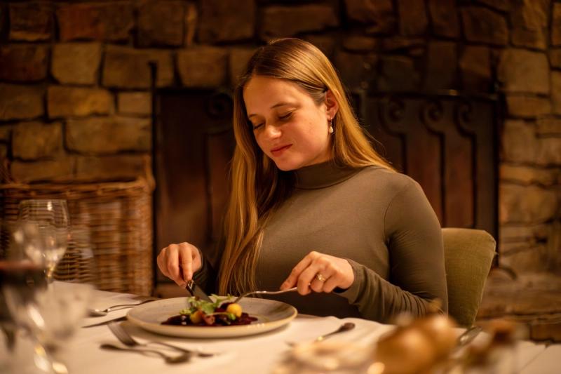 Katharina enjoys a beautifully plated meal by candlelight in a cosy safari lodge during her babymoon safari.