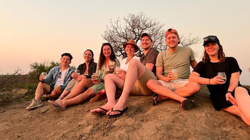 Photograph of the team sitting on a termite mound