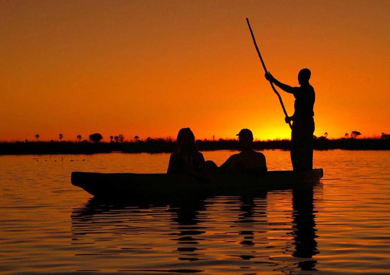 Silhueta de canoa ao pôr do sol no Delta do Okavango