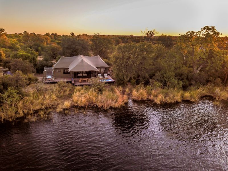 Distant view of Old Drift Lodge along the river