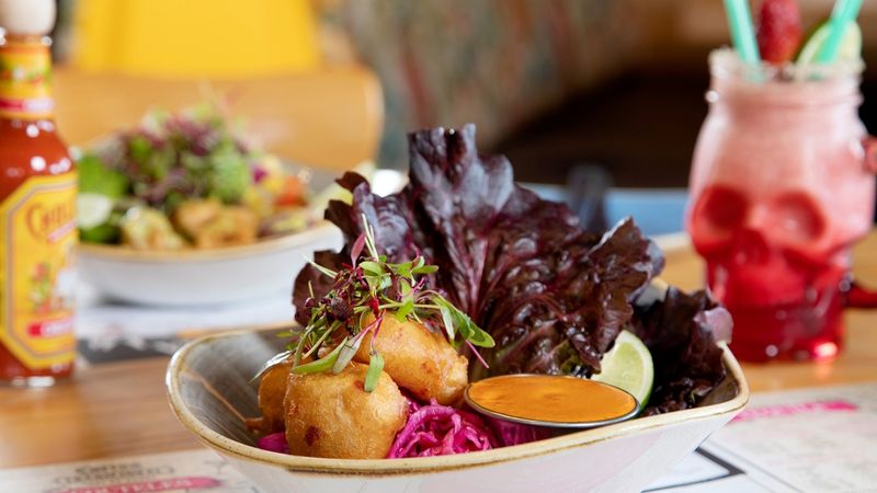 Pescado fritta with salad, fresh garnishing, and a dipping sauce
