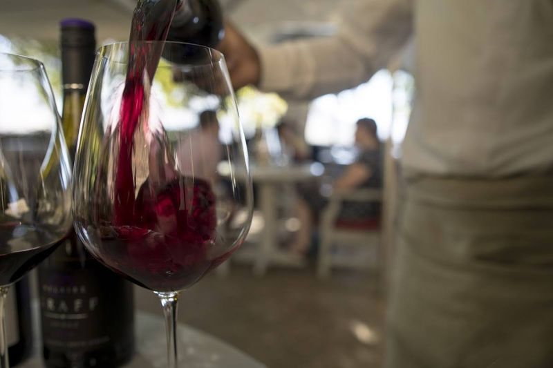 A glass of red wine is poured
