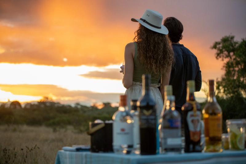 Ein Sundowner auf Safari mit farbenfrohem Sonnenuntergang