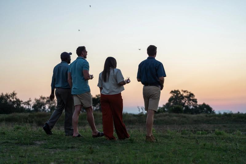 Two guests having sundowners in the Sabi Sand Game Reserve with their guide and tracker