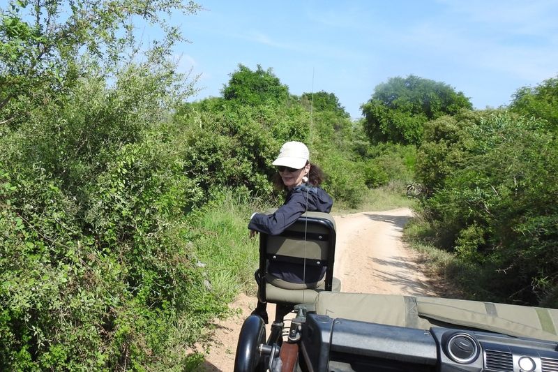 Lindy seated in the Tracker's eat in front of a game drive vehicle