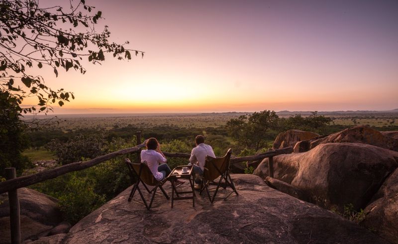 Couple sitting on the kopje observing the sunrise