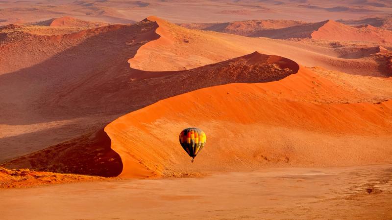 Gliding over the towering, red sand dunes of Sossusvlei in the Namib Desert on a hot air balloon safari