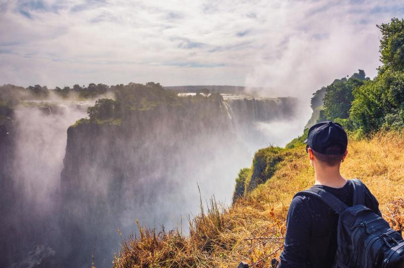 Tourist looks at the Victoria Falls on Zambezi River in Zimbabwe