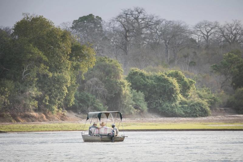 A small boat safari drifts along the Rufiji River, offering a tranquil moment during African travel in June and July