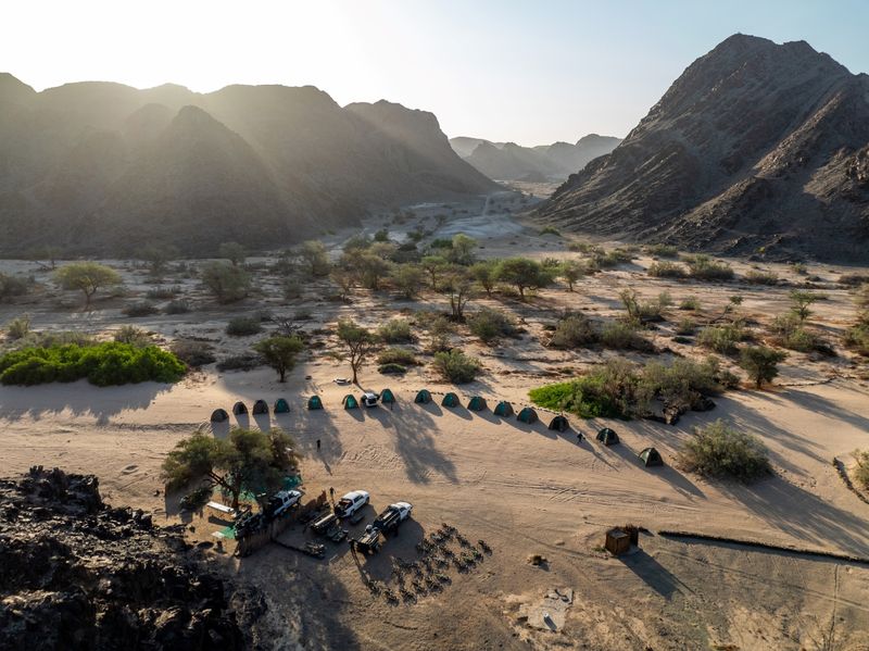 Camp setting featuring tents in a crescent formation