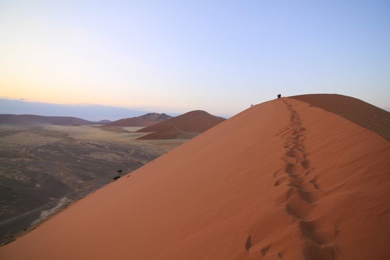 Julia erklimmt orangene Dünen im Sossusvlei