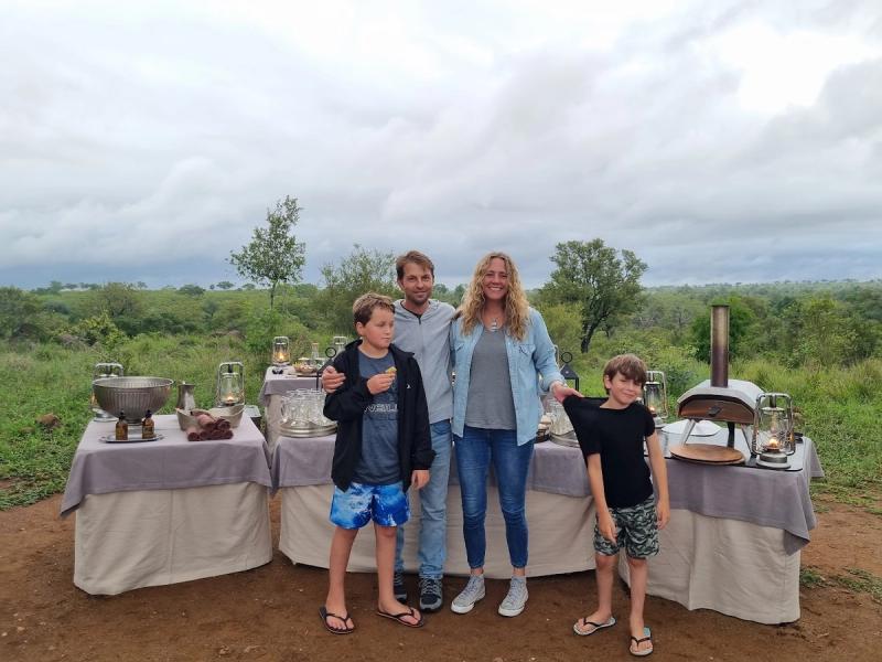 A family stands in front of a buffet while on safari in the Kruger