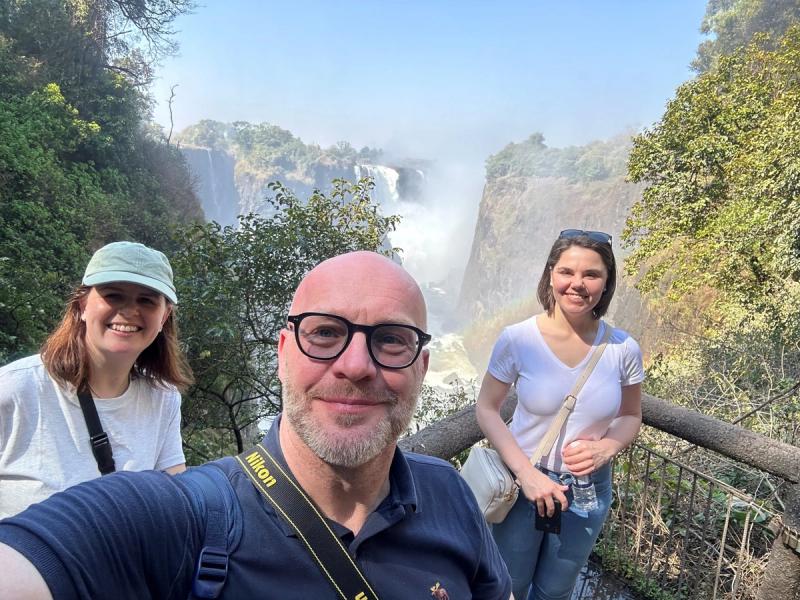 Jan Suhr and Rhino Africa colleagues at a misty Victoria Falls viewpoint.