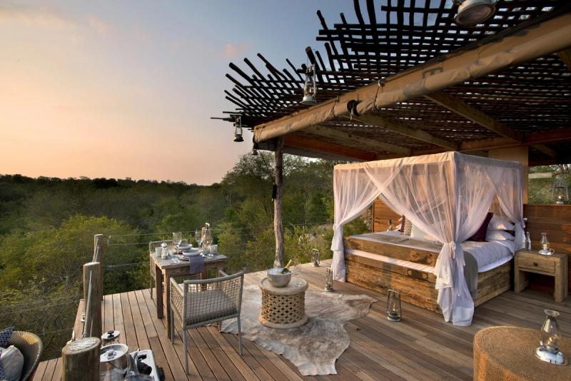 An open-air starbed and dining setup overlook the bush, showing how to stay present in wild spaces built to make you pause