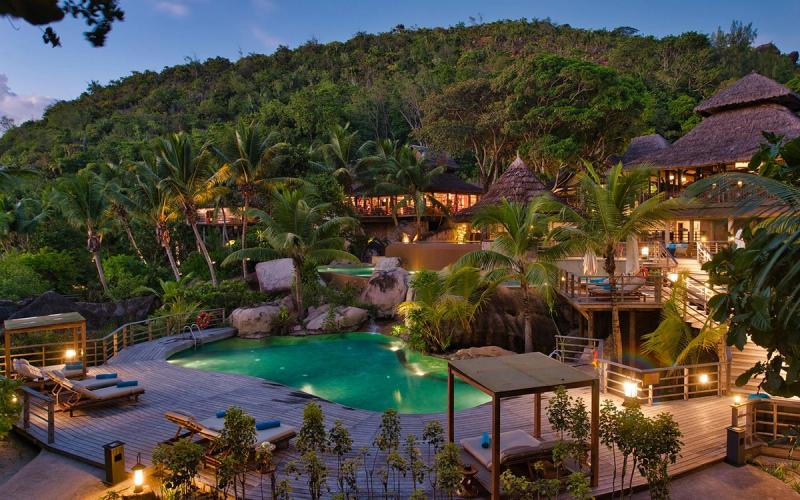 A jungle-wrapped luxury resort glows at twilight