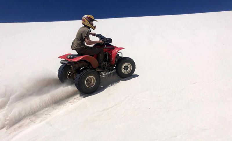 Man on quad bike driving up atlantis dunes