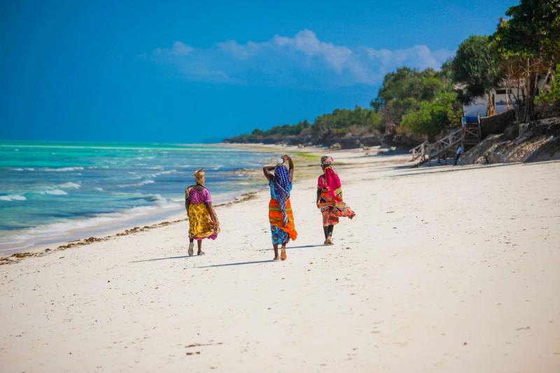 Women walking on the beach in Jambiani, Zanzibar Island