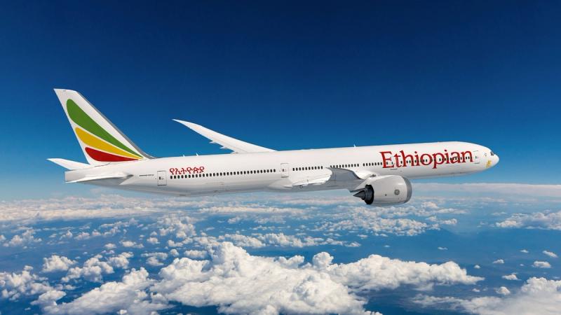 An Ethiopian Airlines plane glides through a clear blue sky, symbolising the growing accessibility of Africa through international flight routes.