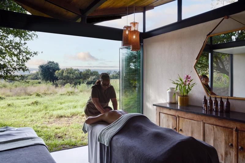 Woman massaging a guest with view of the bush at Lion Sands River Lodge
