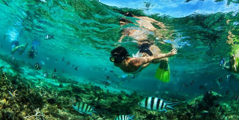 When to visit Mauritius: A woman snorkeling in the sea