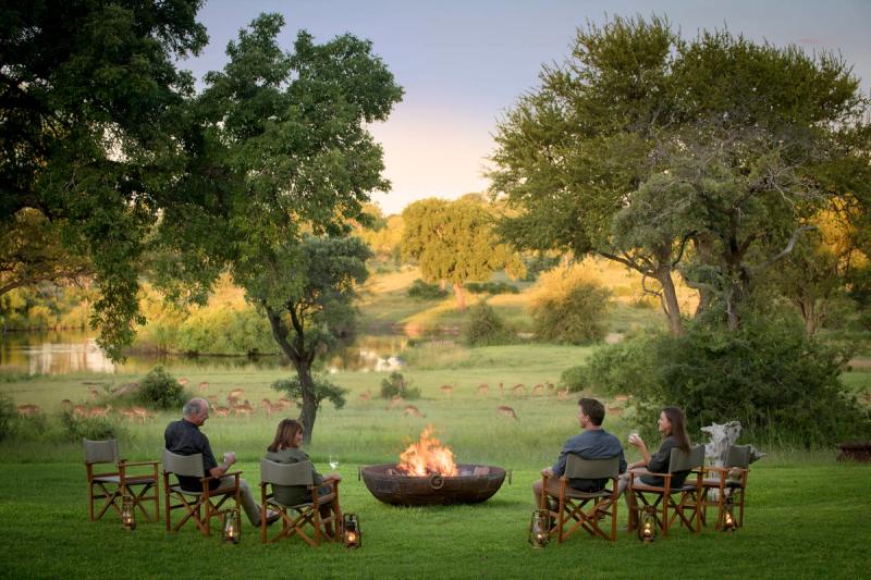Drinks by the fire on safari at Singita Castleton with loved ones